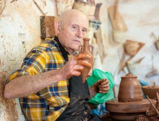 Imagen del alfarero Emili Boix sosteniendo una pieza de barro recién terminada de elaborar al torno