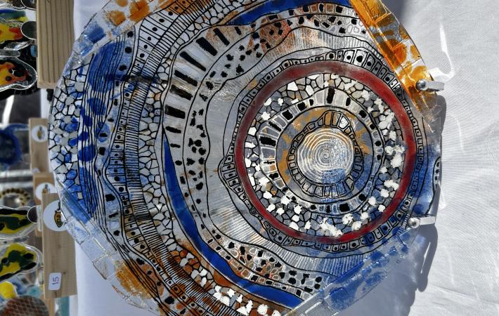 Pieza realizada en vidrio de 3 mm. Posee cortes superpuestos tipo mosaiquismo. Esmaltado con grisallas, micas y polvo de vidrio previo delineado con grisalla negra.