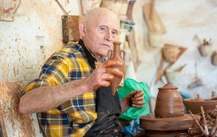 Imagen del alfarero Emili Boix sosteniendo una pieza de barro recién terminada de elaborar al torno