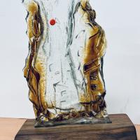 Pieza abstracta realizada en vidrio de 5mm, esmaltada con esmalte de burbuja oro y colocada sobre un pie de madera de olivo.