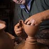 Alfarero haciendo una pieza  de arcilla en el torno de alfarero.
