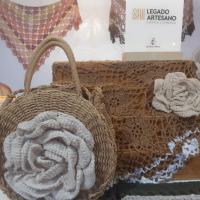 Flores grandes de ganchillo, al fondo un mantón de ganchillos y la placa de Legado Artesano de Castilla-La Mancha